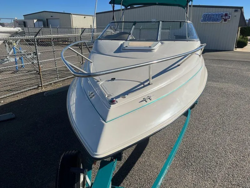 Slide: The Image of 1995 Regal Valanti 222 boat on trailer, parked outdoors near industrial buildings. - 6