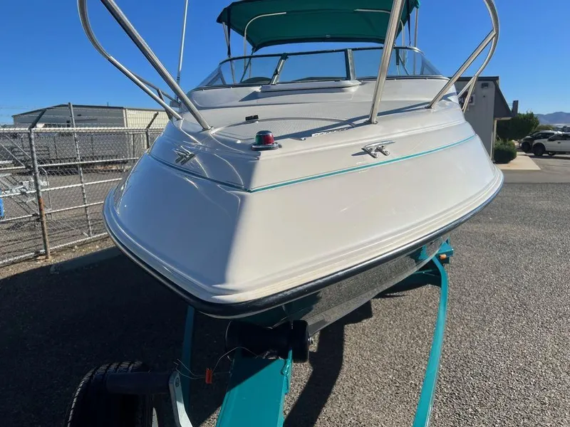 Slide: The Image of 1995 Regal Valanti 222 boat on trailer, white with teal accents, parked outdoors. - 7