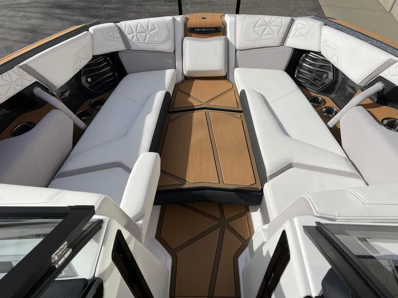 Slide: The Image of 2024 Nautique Super Air Nautique G25 Paragon interior with luxurious white seating and wood accents. - 11