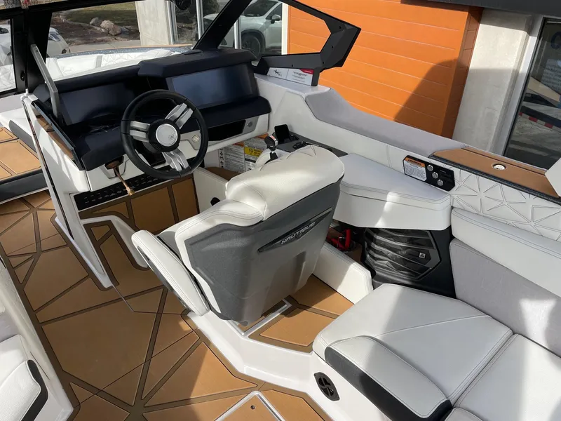 Slide: The Image of Interior of 2024 Nautique Super Air Nautique G25 Paragon boat, featuring modern helm and seating. - 6