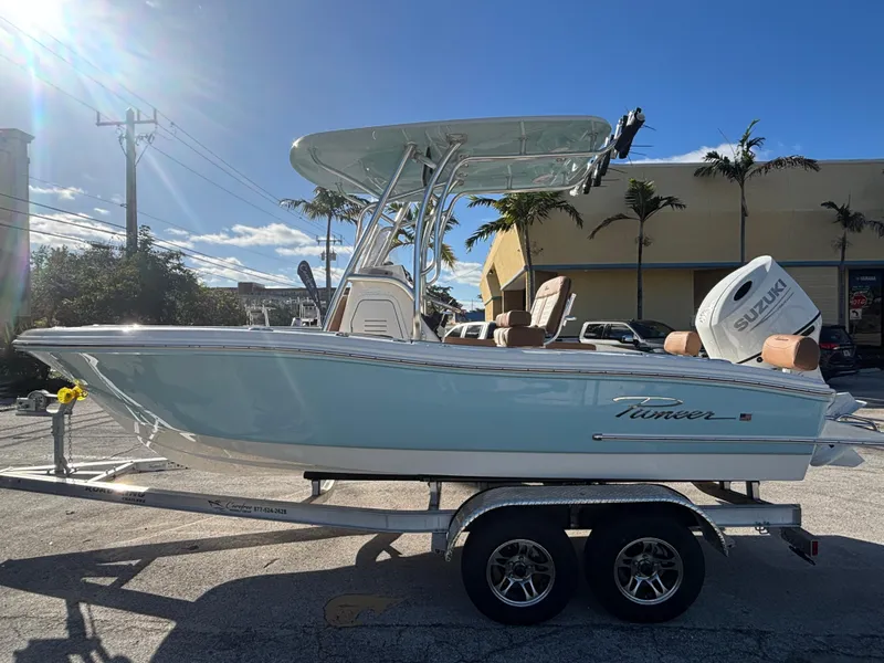 Slide: The Image of 2025 Pioneer 202 Sportfish boat on trailer, sunny day, palm trees in background. - 0