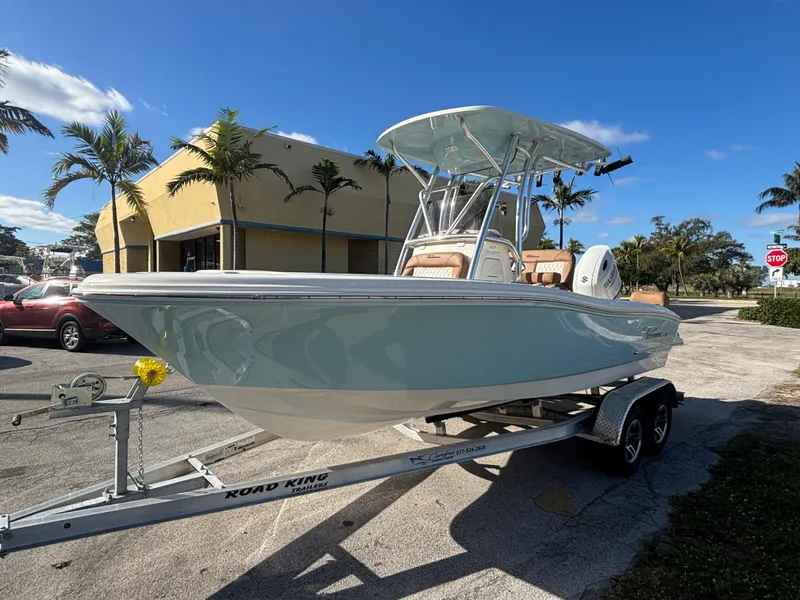 Slide: The Image of 2025 Pioneer 202 Sportfish boat on trailer, parked outdoors under clear blue sky. - 1