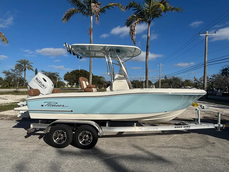 Slide: The Image of 2025 Pioneer 202 Sportfish boat on trailer, parked under palm trees, clear blue sky. - 3