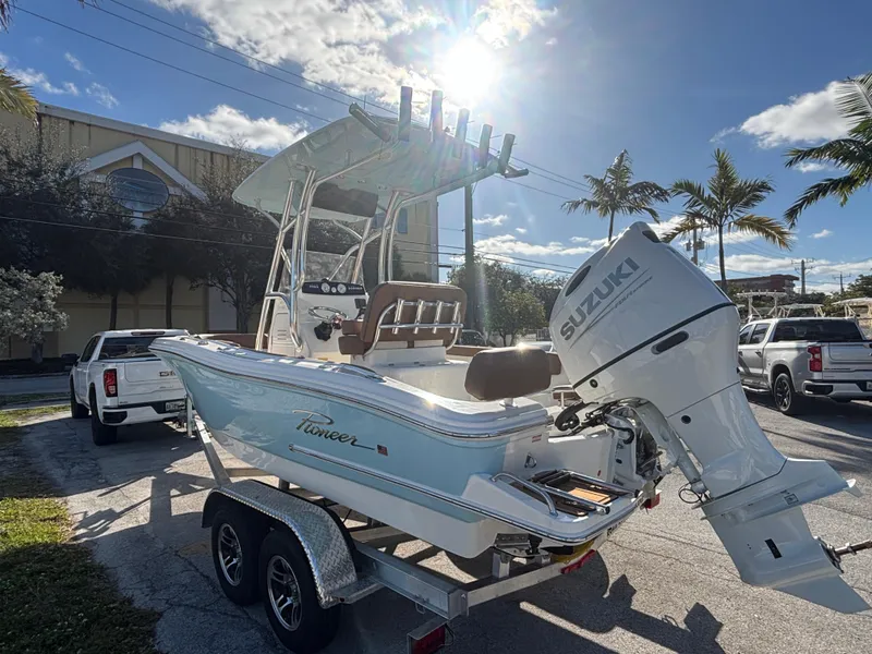 Slide: The Image of 2025 Pioneer 202 Sportfish boat with Suzuki engine on a trailer, sunny day. - 6