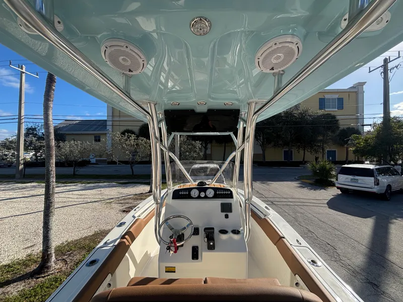 Slide: The Image of 2025 Pioneer 202 Sportfish boat interior with steering wheel and controls, parked outdoors. - 8