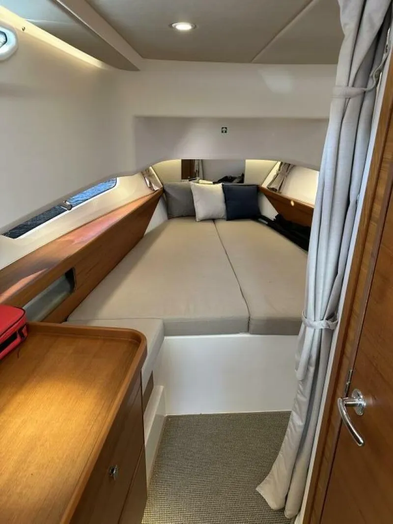 Slide: The Image of Cozy cabin interior of 2022 Nimbus T-11 boat with comfortable bedding and wooden accents. - 12