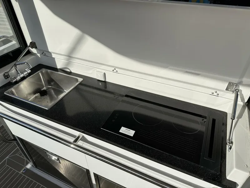 Slide: The Image of Modern kitchen area in 2022 Nimbus T-11 boat with sink and stovetop. - 17