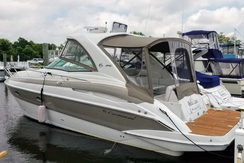 Slide: The Image of 2007 Crownline 340 CR boat docked in marina, featuring sleek design and covered cockpit. - 1