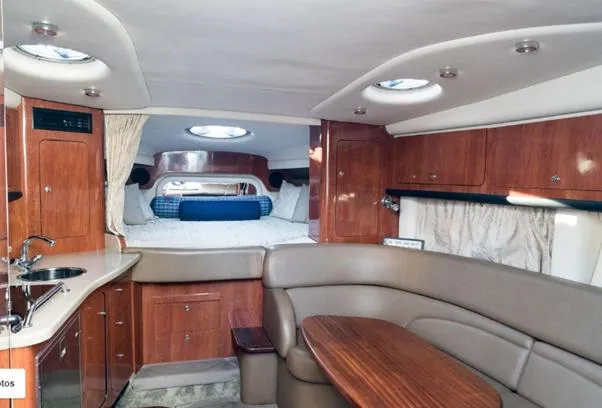 Slide: The Image of Interior of 2007 Crownline 340 CR yacht with wood cabinetry and cozy seating area. - 15