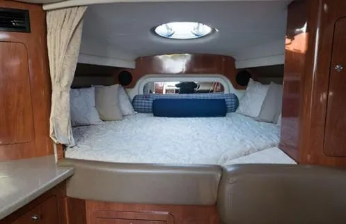 Slide: The Image of Interior cabin of 2007 Crownline 340 CR boat with cozy bed and wood paneling. - 16