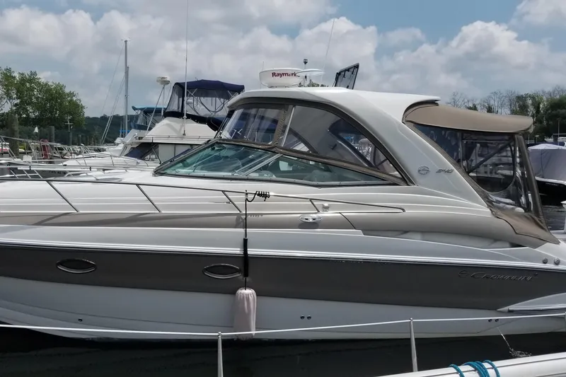 Slide: The Image of 2007 Crownline 340 CR boat docked at marina under cloudy sky. - 2