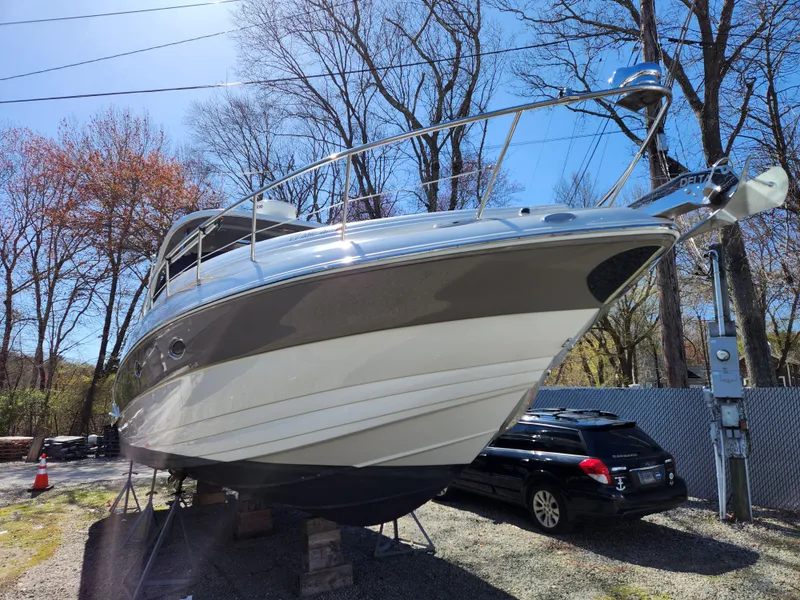 Slide: The Image of 2007 Crownline 340 CR boat on stands, surrounded by trees and parked cars. - 5