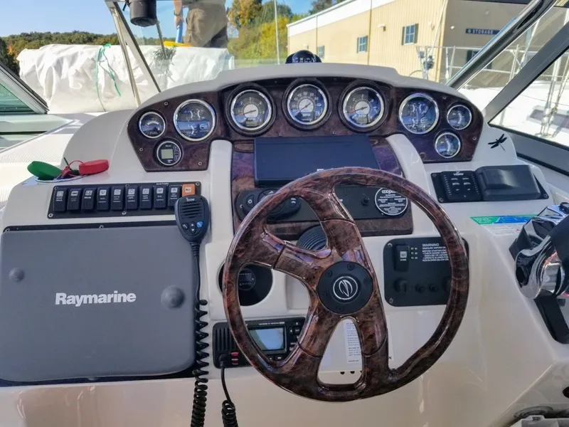 Slide: The Image of Crownline 340 CR 2007 boat dashboard with Raymarine equipment and wood-grain steering wheel. - 9