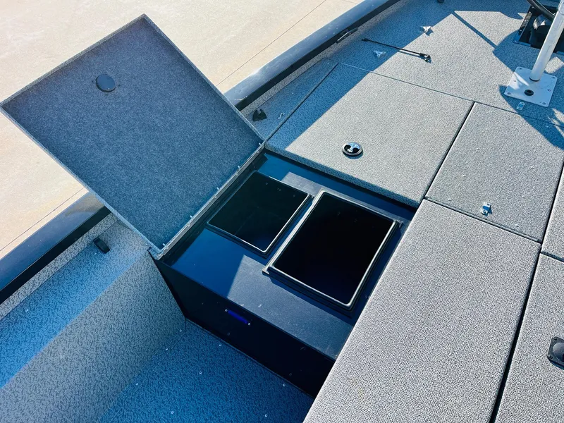 Slide: The Image of 2020 G3 Sportsman 1910 boat storage compartment with open lid and carpeted interior. - 17