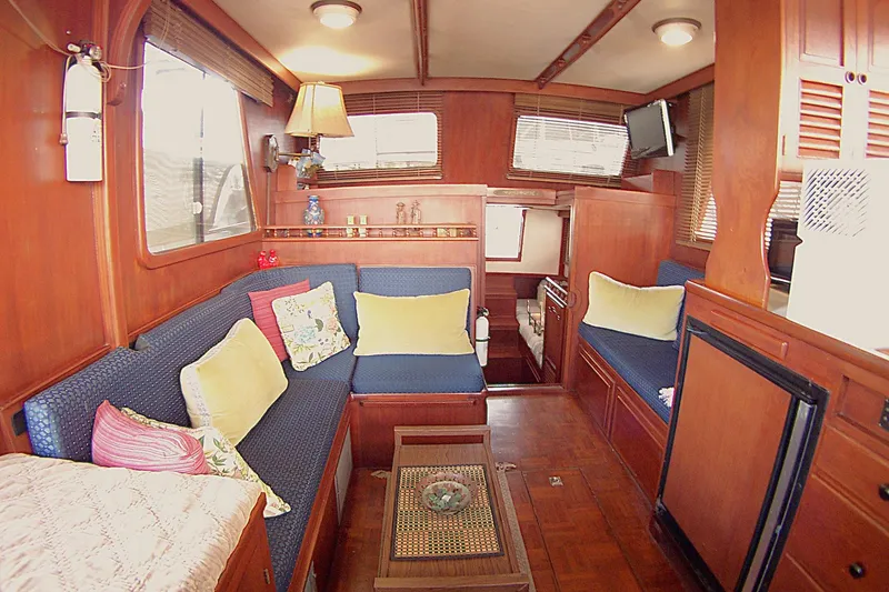 Slide: The Image of Interior of 1983 Marine Trader 34 Trawler with cozy seating and wooden decor. - 13