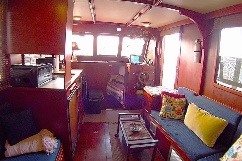 Slide: The Image of Interior of 1983 Marine Trader 34 Trawler with cozy seating and wooden finishes. - 16