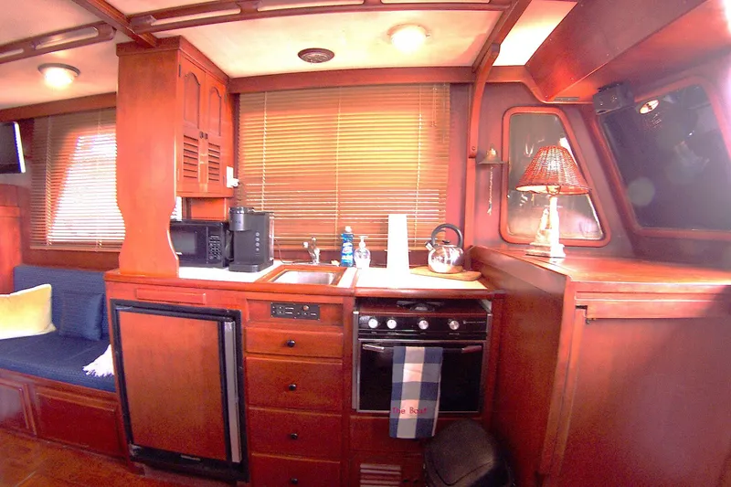 Slide: The Image of 1983 Marine Trader 34 Trawler kitchen with wood cabinetry and appliances. - 17