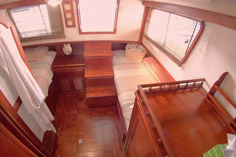 Slide: The Image of 1983 Marine Trader 34 Trawler cabin with twin beds and wooden interior. - 22