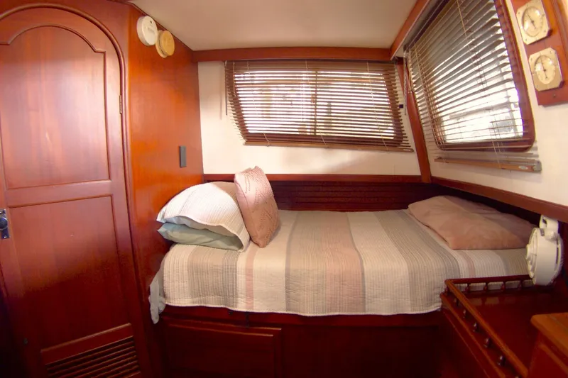 Slide: The Image of Cozy cabin interior of 1983 Marine Trader 34 Trawler with wooden furnishings and bed. - 24