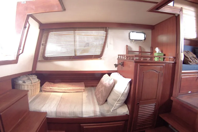 Slide: The Image of Cozy cabin interior of 1983 Marine Trader 34 Trawler with wooden furnishings and bed. - 25