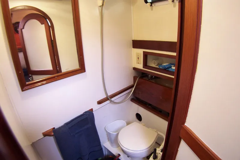 Slide: The Image of 1983 Marine Trader 34 Trawler bathroom with shower, toilet, and wooden accents. - 28