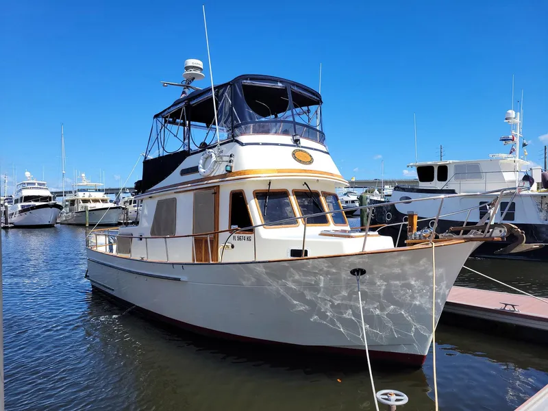 Slide: The Image of 1983 Marine Trader 34 Trawler docked at marina under clear blue sky. - 4