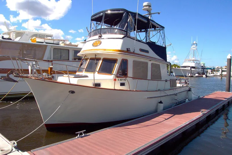Slide: The Image of 1983 Marine Trader 34 Trawler docked at marina under blue sky. - 40