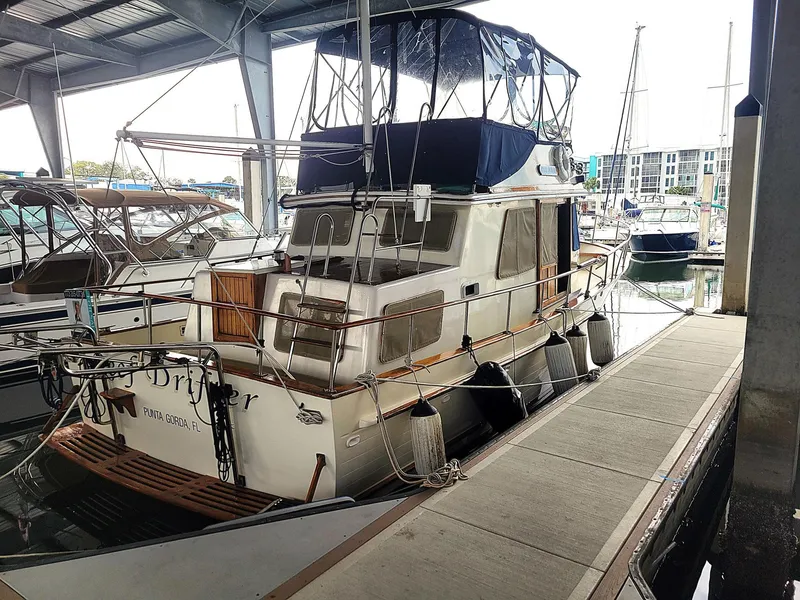 Slide: The Image of 1983 Marine Trader 34 Trawler docked in a marina under a covered shelter. - 6