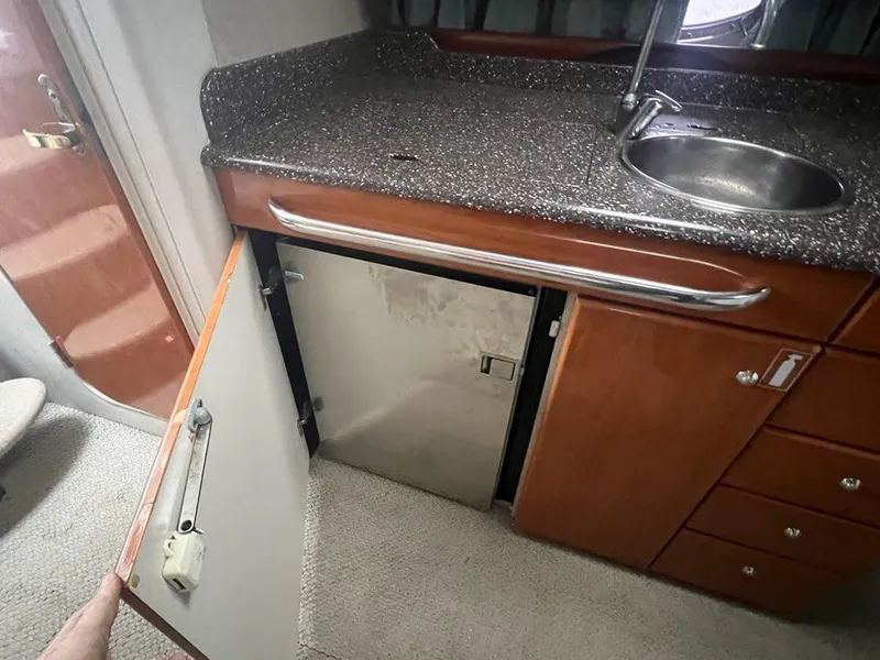 Slide: The Image of 2004 Formula 34 PC yacht interior with kitchenette, sink, and open cabinet. - 16