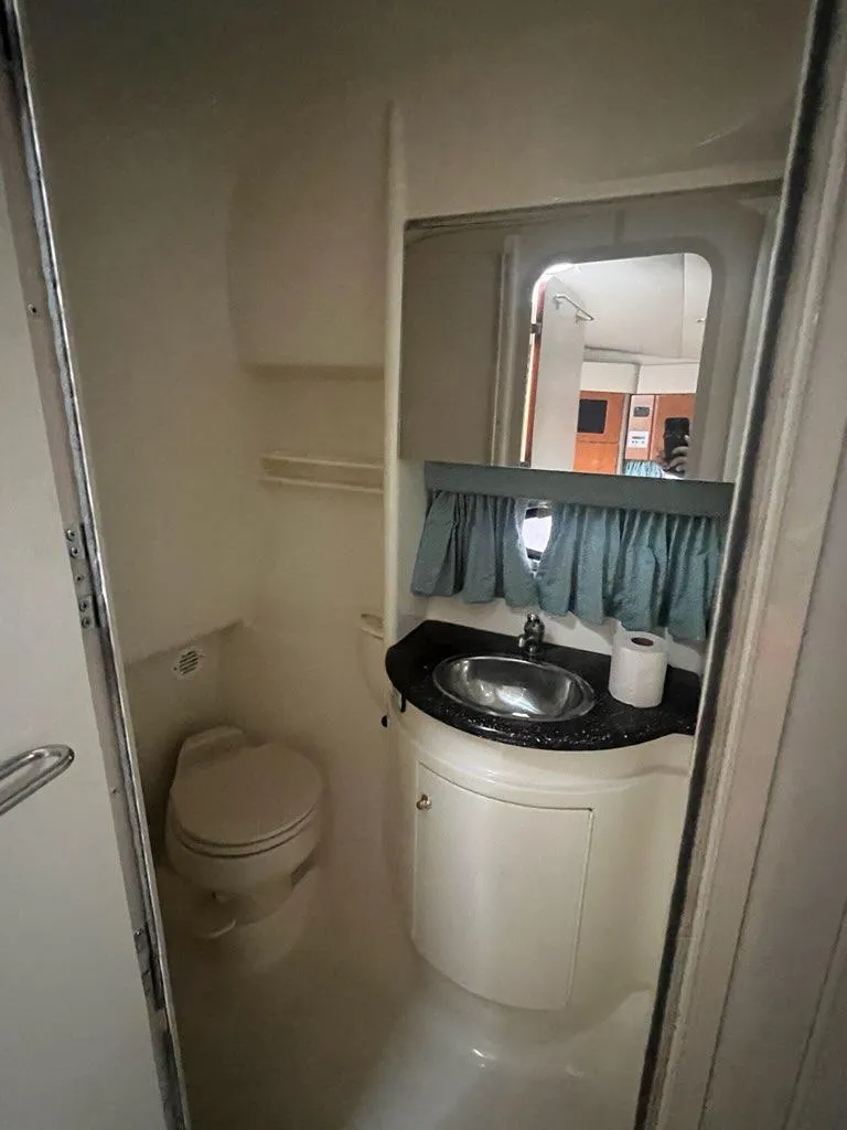 Slide: The Image of 2004 Formula 34 PC boat bathroom with sink, toilet, and mirror. - 22