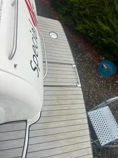 Slide: The Image of 2004 Formula 34 PC boat deck with "Special" branding, docked near greenery. - 8