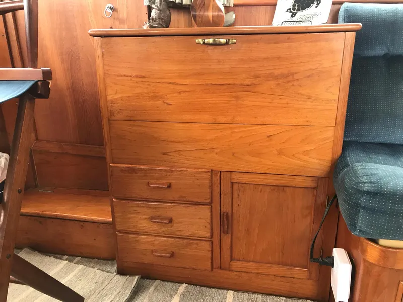 Slide: The Image of Wooden cabinetry inside a 1969 Grand Banks 42 Classic boat, featuring drawers and a small door. - 16