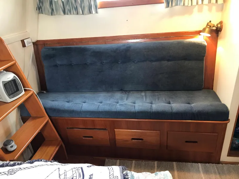 Slide: The Image of Interior of 1969 Grand Banks 42 Classic with blue cushioned seating and wooden storage drawers. - 24