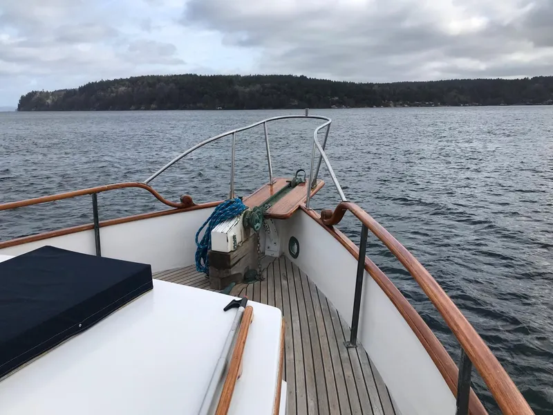 Slide: The Image of 1969 Grand Banks 42 Classic yacht on calm waters with scenic shoreline view. - 28