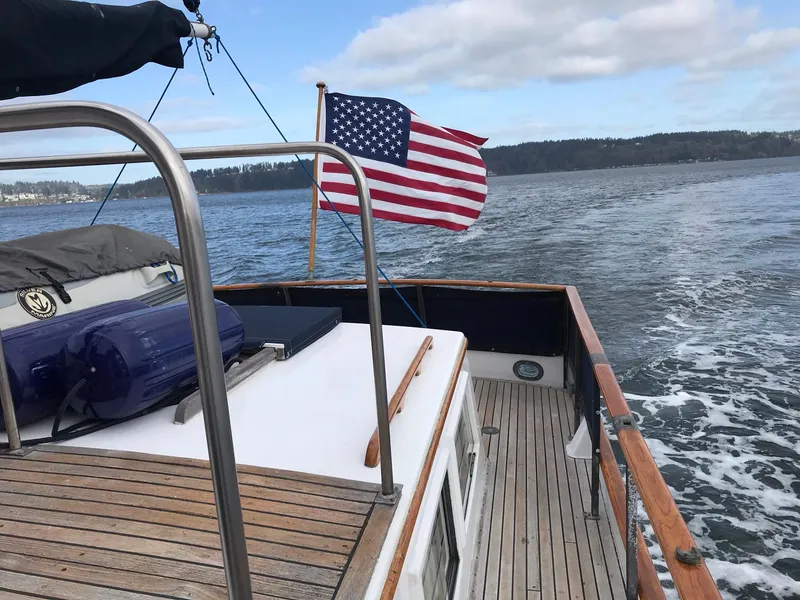 Slide: The Image of 1969 Grand Banks 42 Classic yacht with American flag, cruising on open water. - 3