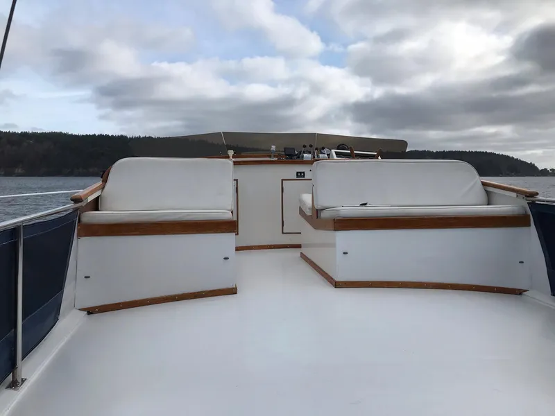 Slide: The Image of 1969 Grand Banks 42 Classic yacht deck with seating, under cloudy sky. - 31