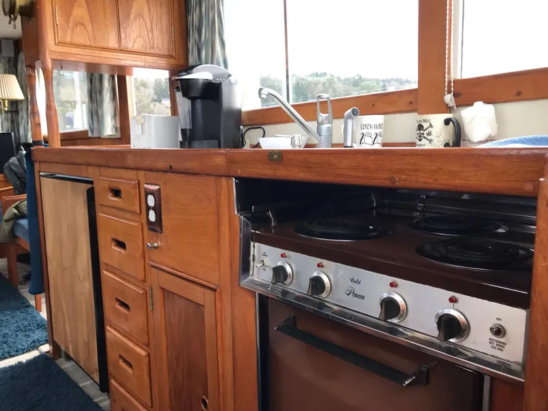 Slide: The Image of Vintage 1969 Grand Banks 42 Classic yacht kitchen with wooden cabinetry and stove. - 38