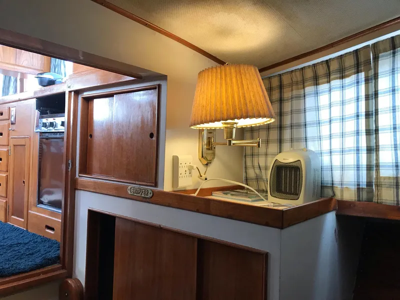 Slide: The Image of Interior of 1969 Grand Banks 42 Classic with wood cabinetry and cozy lamp. - 5