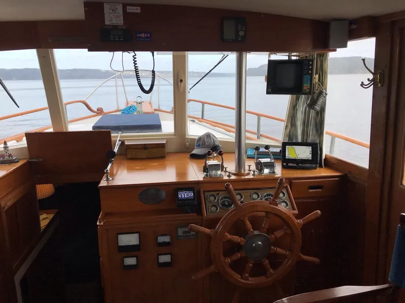 Slide: The Image of Helm of 1969 Grand Banks 42 Classic yacht with wooden wheel and navigation equipment. - 8