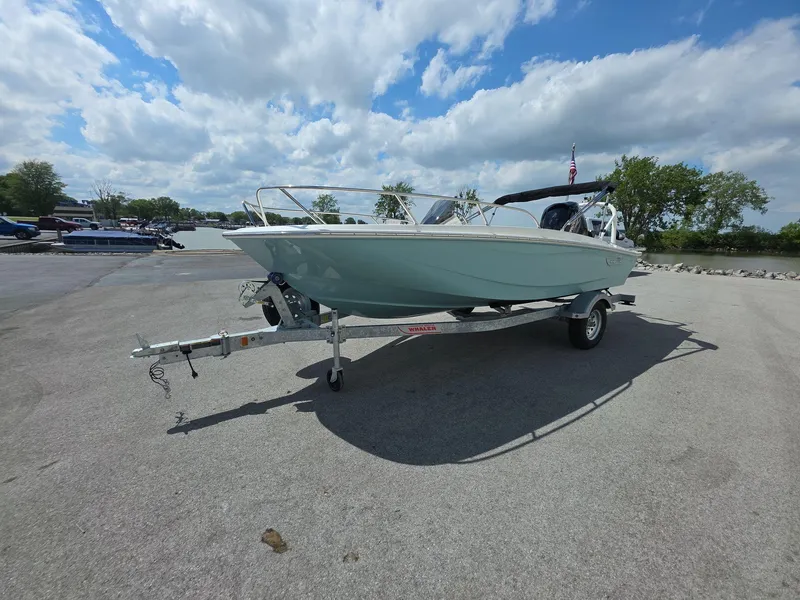 Slide: The Image of 2025 Boston Whaler 160 Super Sport boat on trailer under a partly cloudy sky. - 2