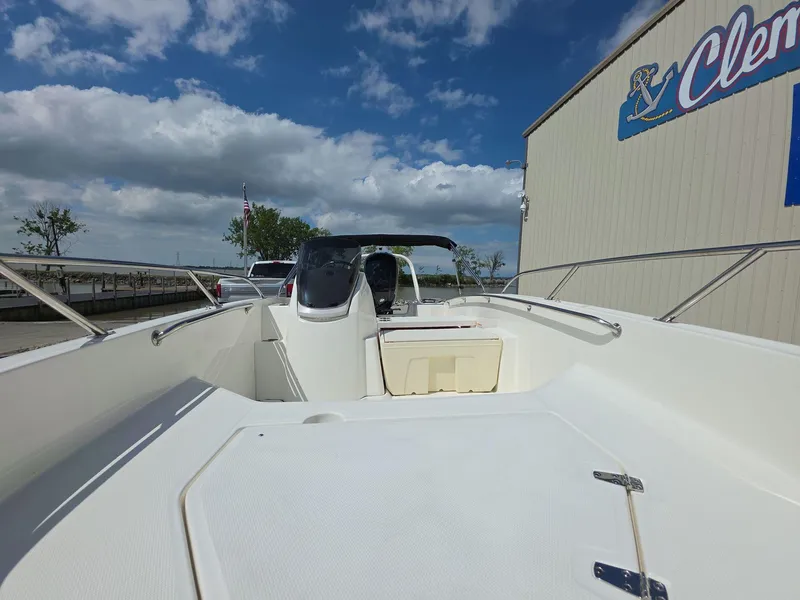 Slide: The Image of 2025 Boston Whaler 160 Super Sport boat docked under a cloudy sky. - 9