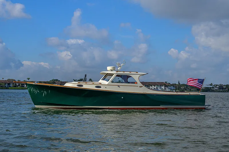 The Image of 2000 Hinckley Picnic Boat Classic on water, American flag, blue sky background. - 1
