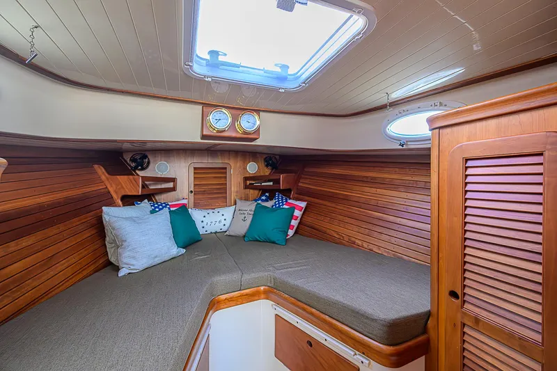 Slide: The Image of Cozy cabin interior of 2000 Hinckley Picnic Boat Classic with wood paneling and cushions. - 18