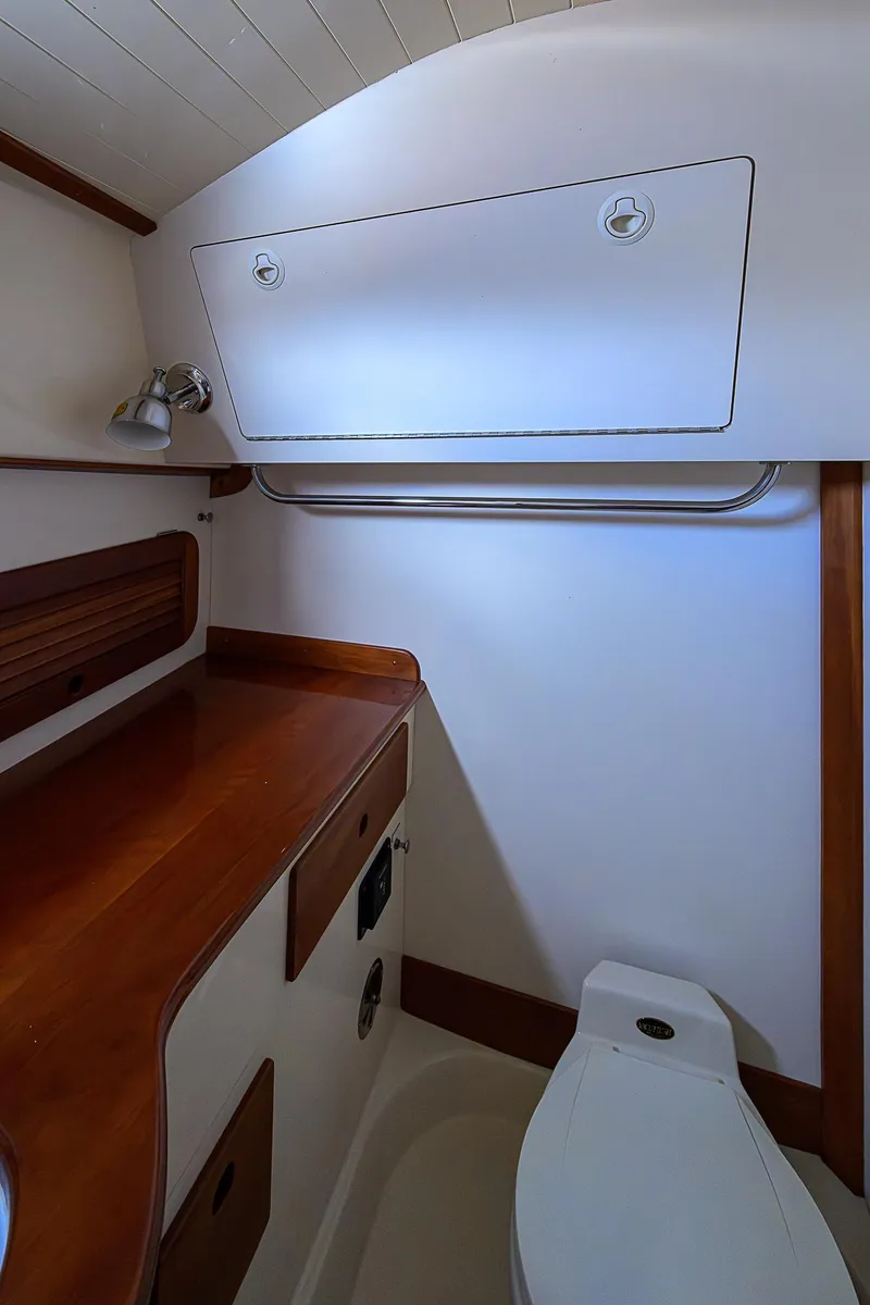 Slide: The Image of 2000 Hinckley Picnic Boat Classic interior with wooden cabinetry and compact bathroom. - 21
