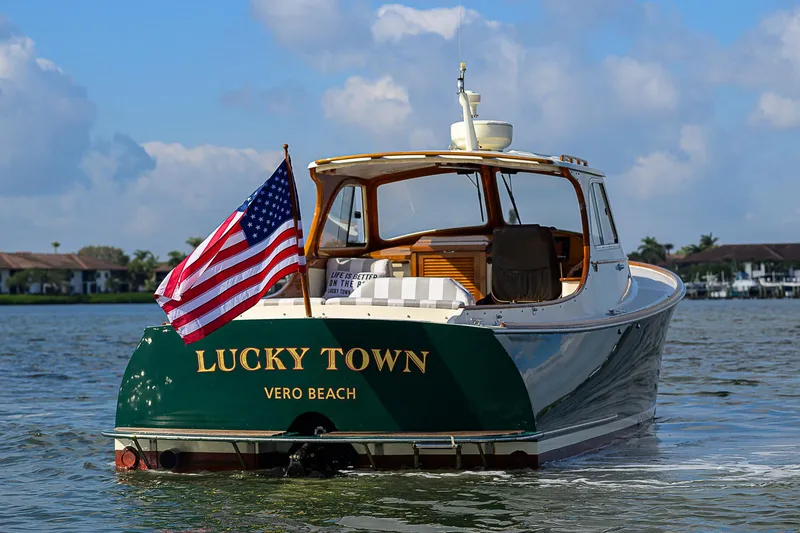 Slide: The Image of 2000 Hinckley Picnic Boat Classic on water, American flag, "Lucky Town" text, Vero Beach. - 4