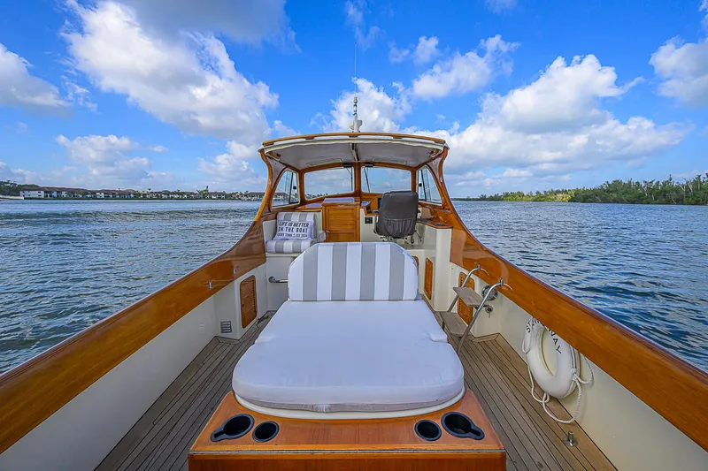 Slide: The Image of 2000 Hinckley Picnic Boat Classic on water, featuring elegant wooden deck and seating. - 7