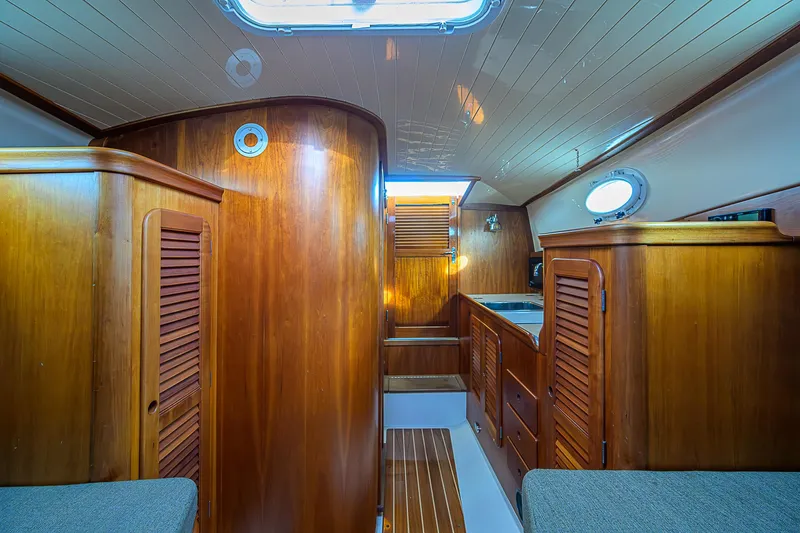 Slide: The Image of Interior of 2000 Hinckley Picnic Boat Classic with wooden cabinetry and cozy seating. - 13