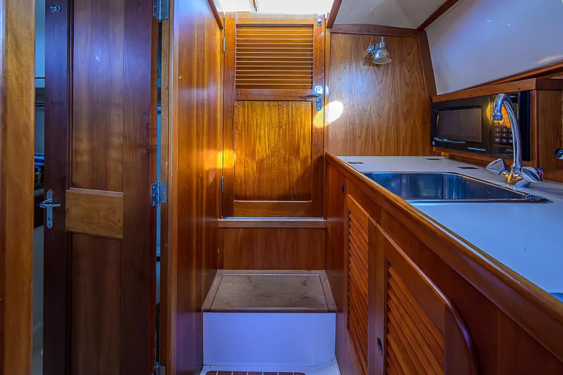 Slide: The Image of Interior of 2000 Hinckley Picnic Boat Classic with wooden cabinetry and stainless steel sink. - 17