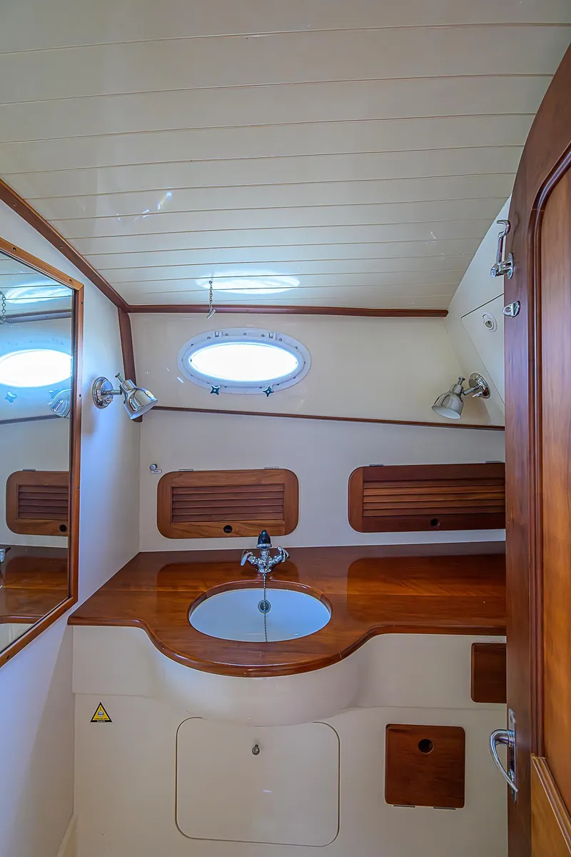 Slide: The Image of 2000 Hinckley Picnic Boat Classic interior with wooden cabinetry and round sink. - 20