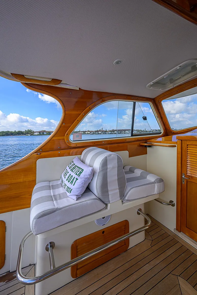 Slide: The Image of Hinckley Picnic Boat Classic 2000 interior with striped seating and scenic water view. - 8